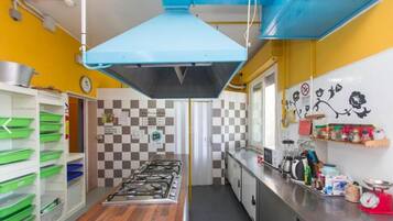 Una cocina con estufa a gas, salpicadero a cuadros y diversos electrodomésticos.