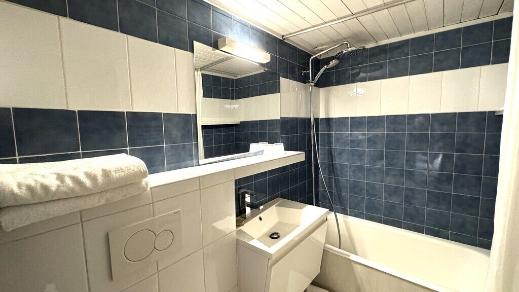 Un baño con bañera, lavamanos y ducha.