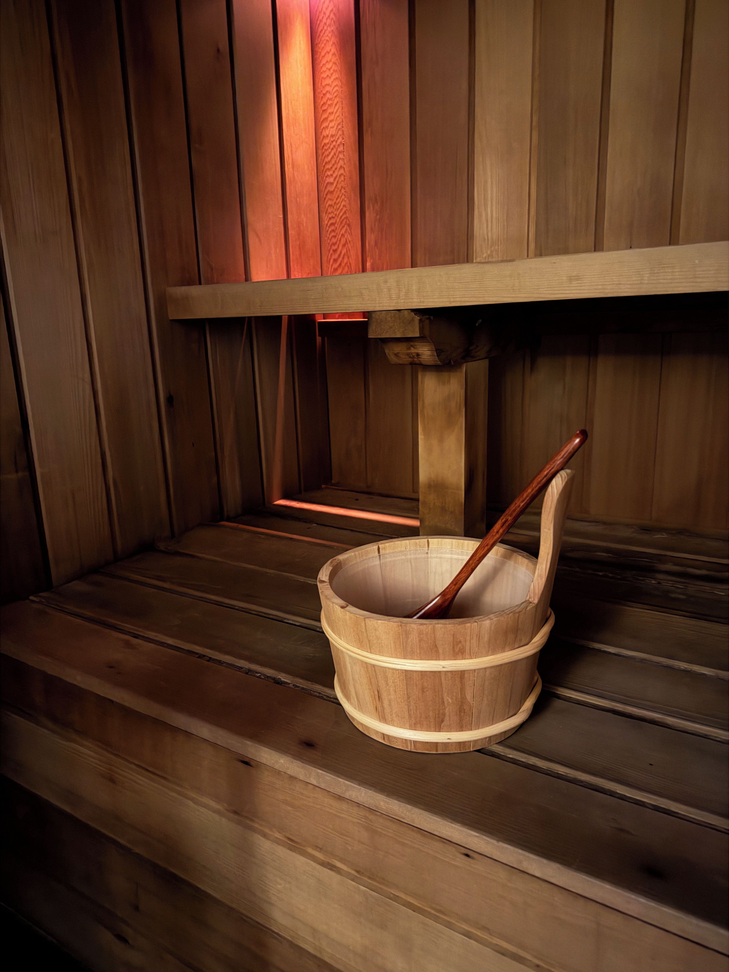 A wooden sauna with a wooden bucket and a wooden ladle.