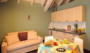 Un salón acogedor con un sofá y una mesa de comedor lista para el desayuno.