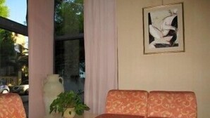 Quarto com sofá, uma mesinha e um vaso de planta.