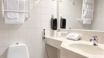 Een badkamer met toilet, wastafel, handdoekhouder en handdroger.