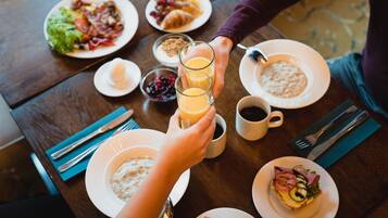 Un desayuno con diversos platos, como huevos, tostadas y fruta.