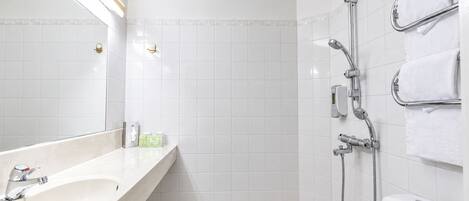 A modern bathroom with a bathtub, a shower with a handheld showerhead, and a toilet.