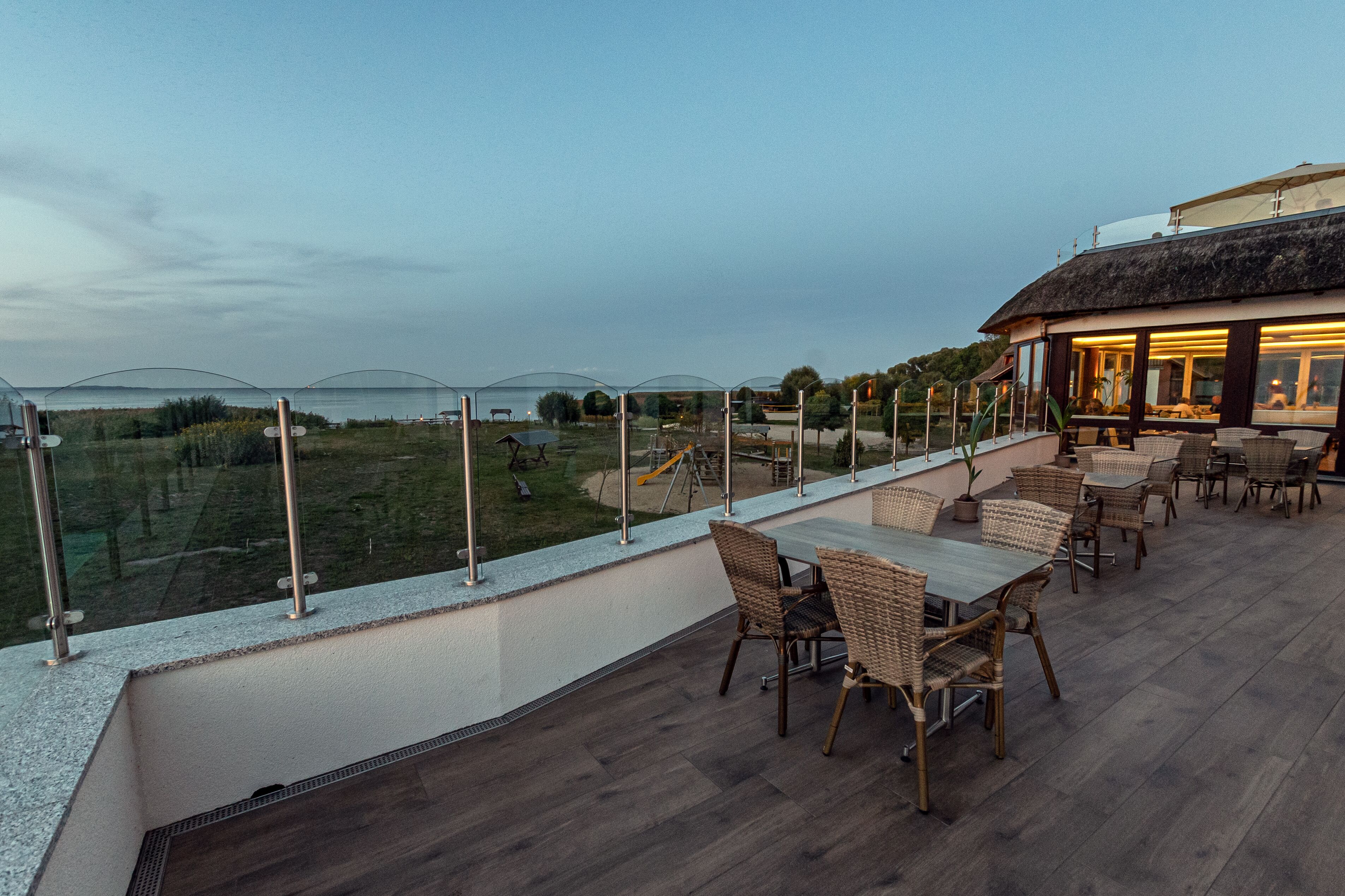 Un patio al aire libre con mobiliario de mimbre y vistas al paisaje.