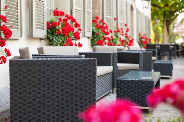 Outdoor wicker furniture arranged along a building's exterior. - SEELANDHOTEL Weisses Kreuz (Lyss)