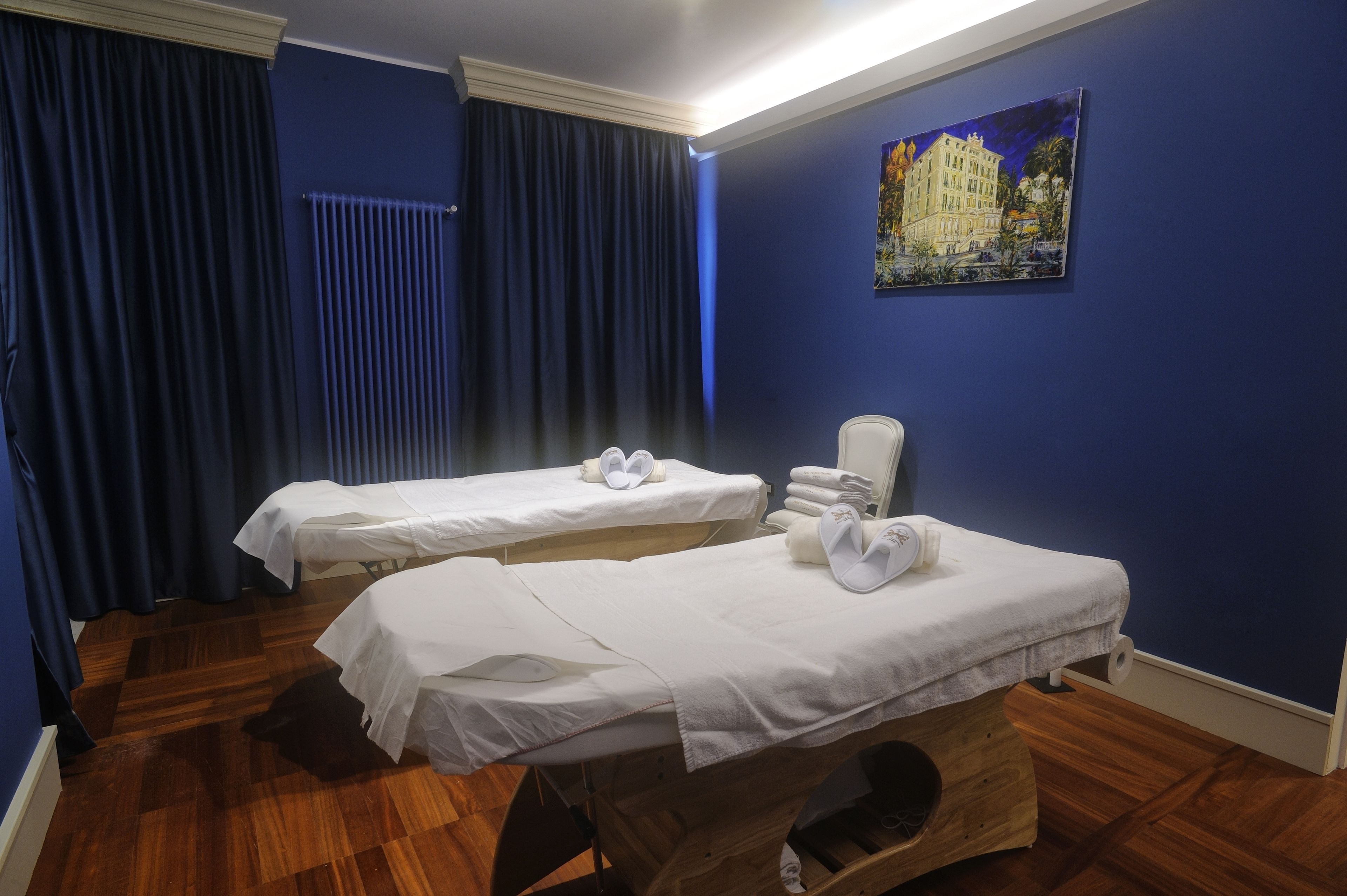 Una habitación con dos camas, una silla y un cuadro en la pared.