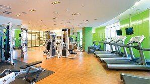 A gym with treadmills, weight machines, and a mirror. - Mayhills Resort (Jeongseon)