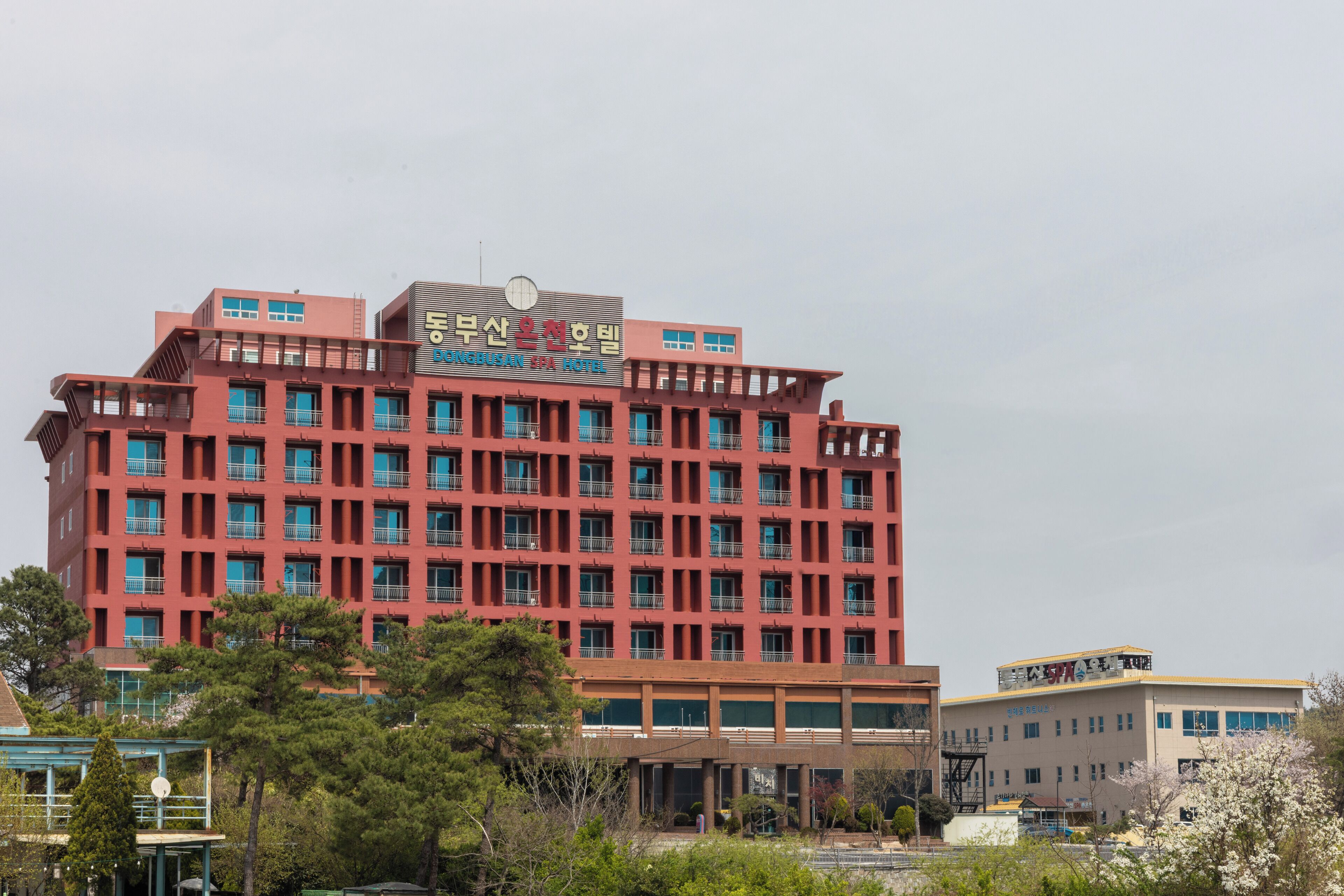 Ein mehrstöckiges Hotel mit roter Fassade und mehreren Balkonen.