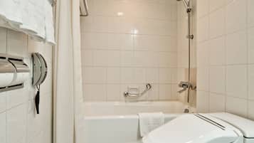 A modern bathroom with a toilet, bathtub, and shower.