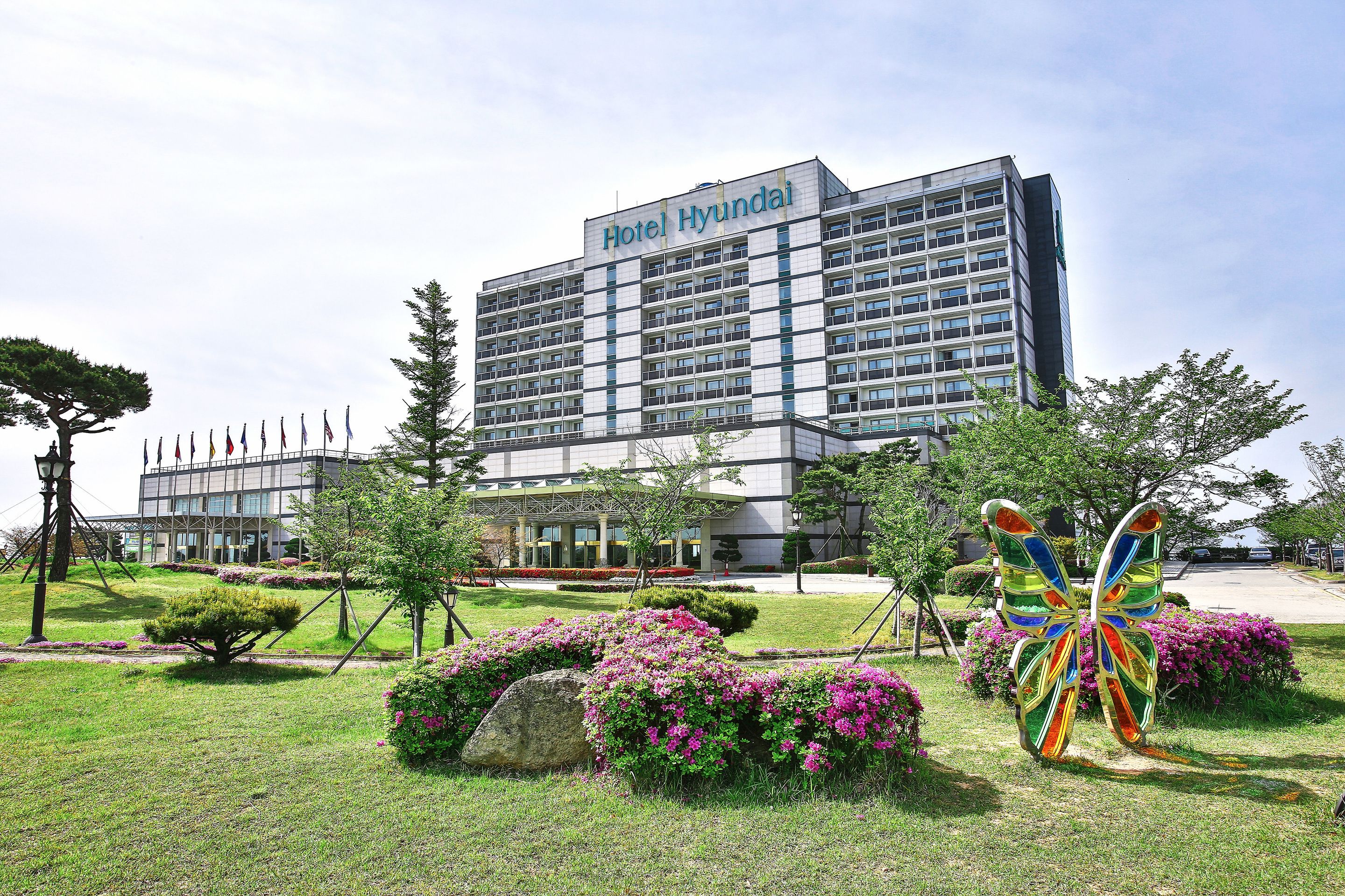 A modern hotel building with a large sign reading "Hotel Hyundai."