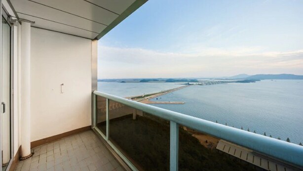 A balcony with a view of a large body of water and distant landforms.