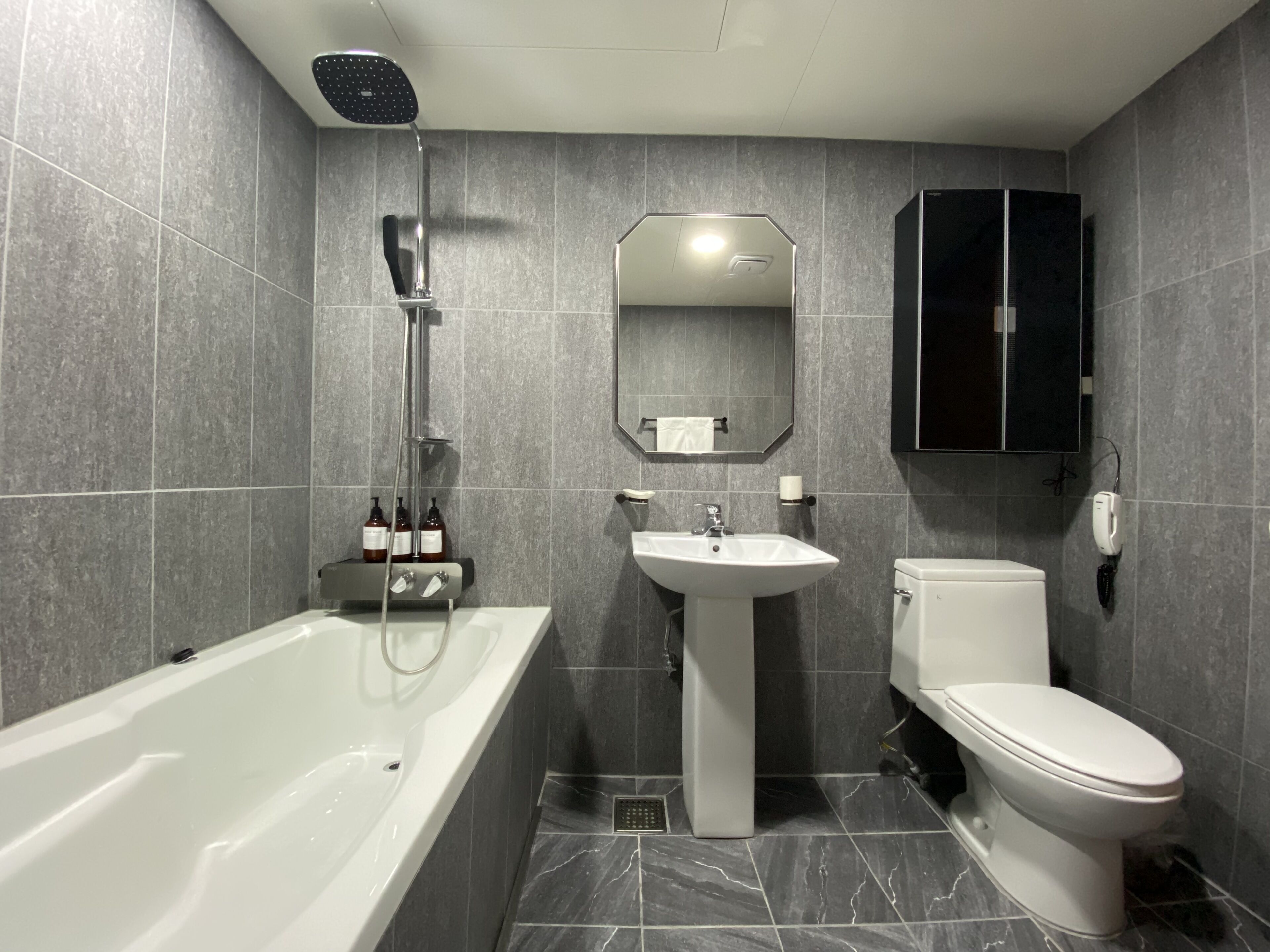 A modern bathroom with a bathtub, a sink, and a toilet.