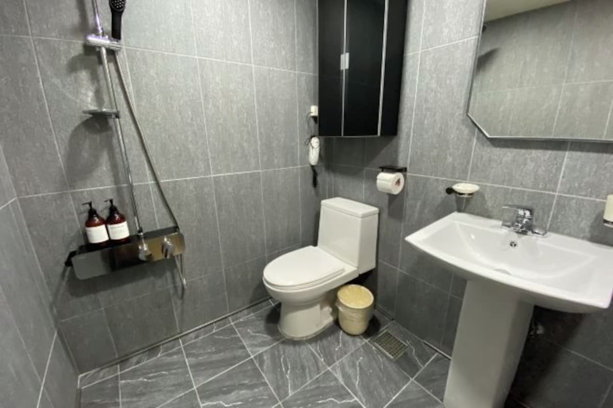 A modern bathroom with a toilet, sink, and shower.