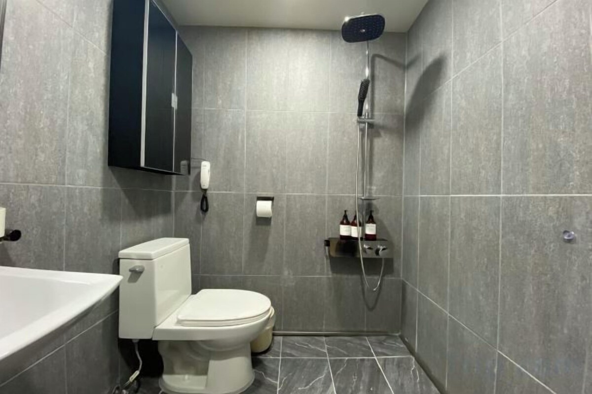 Bañera con ducha, artículos de tocador de diseñador, secador de pelo