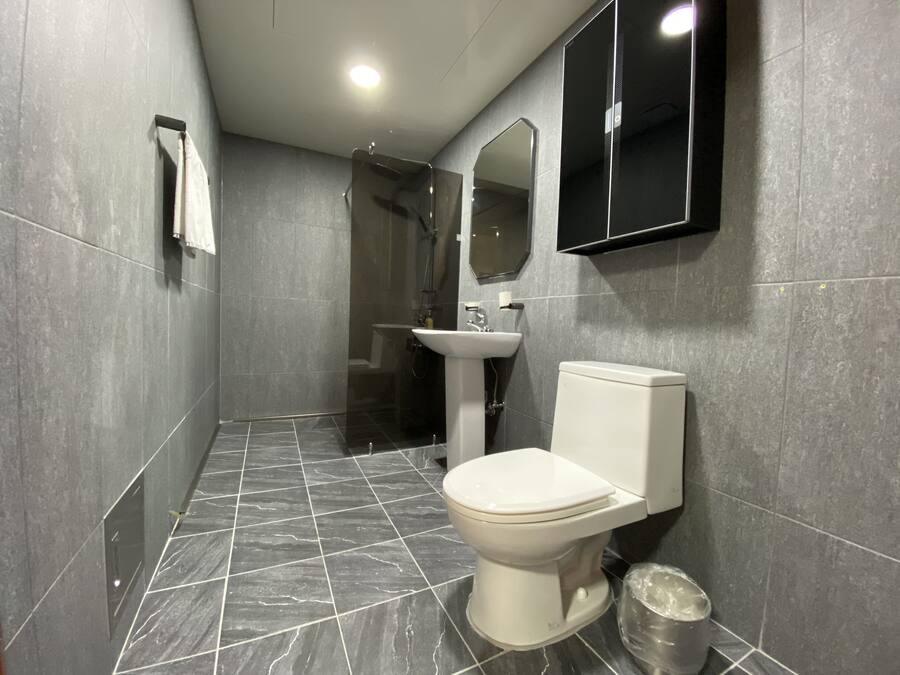 A modern bathroom with a toilet, sink, and shower.