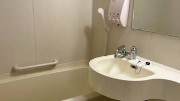 A bathroom with a white sink, a handheld showerhead, a towel hanging on a rack, and a soap dispenser on the wall.