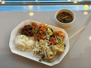A plate of food including rice, noodles, vegetables, and dumplings, with a bowl of soup on a table. - Toyoko Inn Busan Station No.1 (Busan)