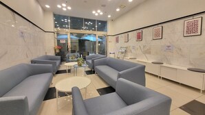A modern lobby with grey sofas, a reception desk, and framed artwork on the walls. - Toyoko Inn Busan Jungang Station (Busan)