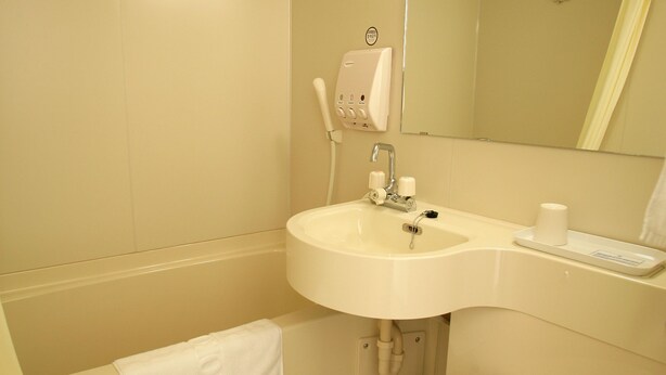 A bathroom with a toilet, sink, and mirror. - Toyoko Inn Busan Jungang Station (Busan)