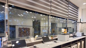 A modern reception desk with multiple laptops, a computer monitor, and a plush toy. - Toyoko Inn Busan Jungang Station (Busan)