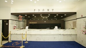 A reception desk with a marble counter, a blue carpet, and a sign above that reads "FRONT". - Toyoko Inn Busan Jungang Station (Busan)