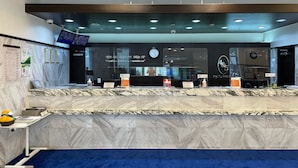A reception desk with a marble top, a clock, and a digital screen above it. - Toyoko Inn Busan Seo-myeon (Busan)