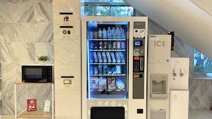 A vending machine with a variety of drinks and a microwave on a marble-tiled counter. - Toyoko Inn Busan Seo-myeon (Busan)