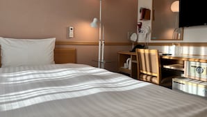 A hotel room with a bed, a desk, a chair, a lamp, a mirror, and a television. - Toyoko Inn Busan Seo-myeon (Busan)