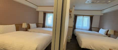 Une chambre d’hôtel avec deux lits, un miroir et un plafond équipé de luminaires.