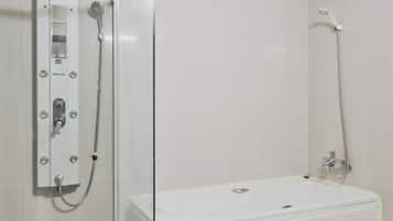 A bathroom with a glass-enclosed shower, a white bathtub, and a marble countertop with a sink.