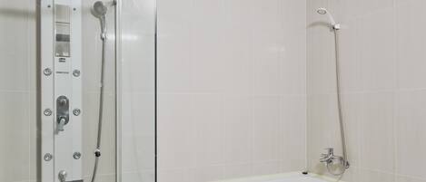 A bathroom with a shower enclosure, a bathtub, and tiled walls.