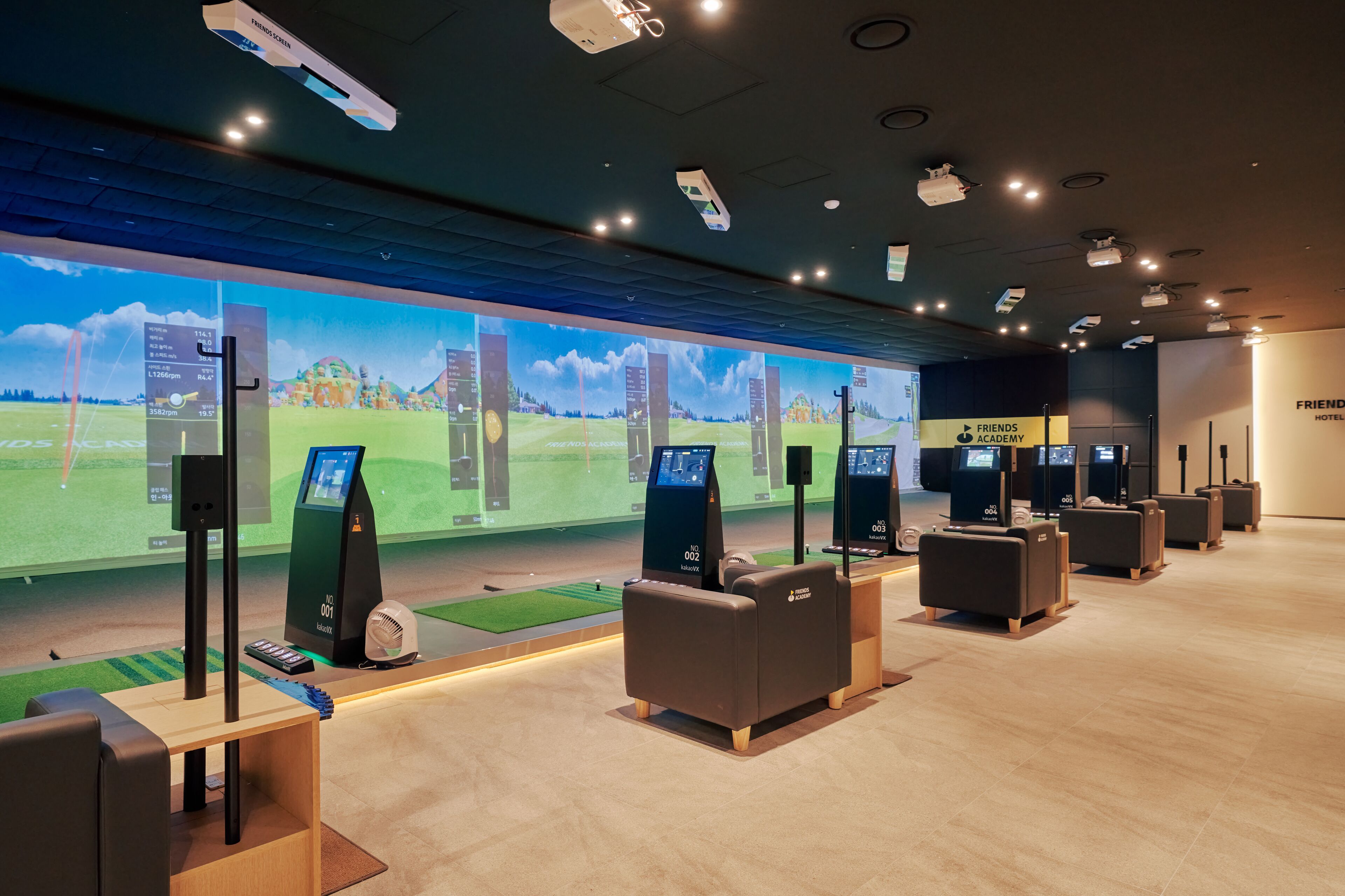 Un hall d’hôtel moderne doté d’un grand écran numérique affichant un parcours de golf, de plusieurs bornes en libre-service et d’espaces de détente confortables.