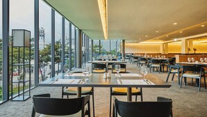 A spacious dining area with large windows, tables set for dining, and a view of the cityscape. - Phoenix Hotel Pyeongchang (Pyeongchang)
