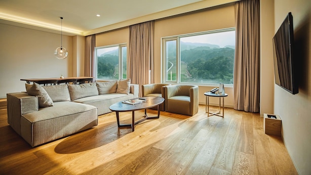 A modern living room with a sectional sofa, a coffee table, and a TV. - Phoenix Hotel Pyeongchang (Pyeongchang)