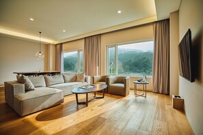A modern living room with a sectional sofa, a coffee table, and a TV. - Phoenix Hotel Pyeongchang (Pyeongchang)