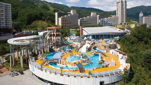 A resort with a large pool area, a water slide, and a building with a curved roof. - Phoenix Hotel Pyeongchang (Pyeongchang)