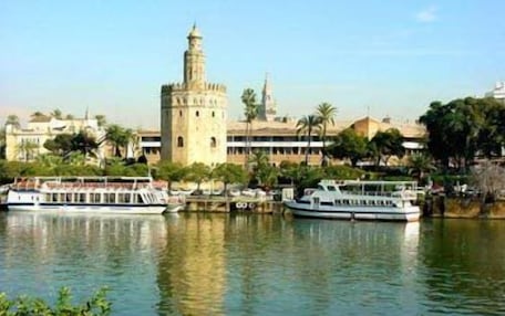 A waterfront view with a prominent tower and several boats docked.