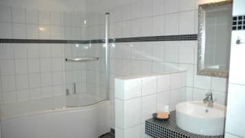 Un baño moderno con bañera, ducha y lavamanos.