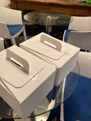 A dining area with white chairs and a glass table. - My Hotel Milano (Milan)