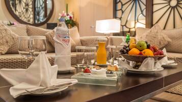 A breakfast setting with a fruit bowl, juice, and a cake on a table.