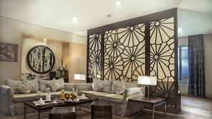 Una sala de estar moderna con un sofá modular, una mesa de centro y un biombo decorativo.