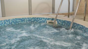Relax in a spacious hot tub with a clear view of the water's surface, featuring handrails for support.