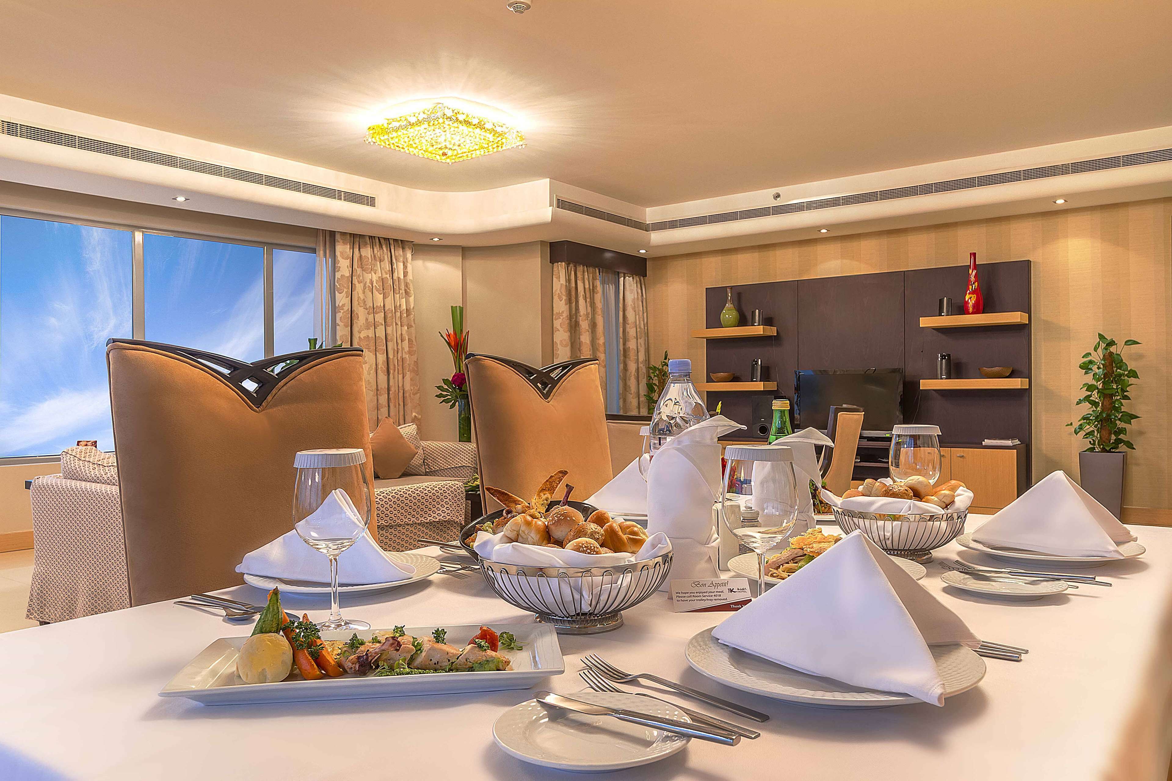 A dining area with a table set for a meal, including plates, cutlery, and a variety of dishes.
