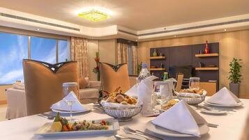 A dining area with a table set for a meal, including plates, cutlery, and a variety of dishes.