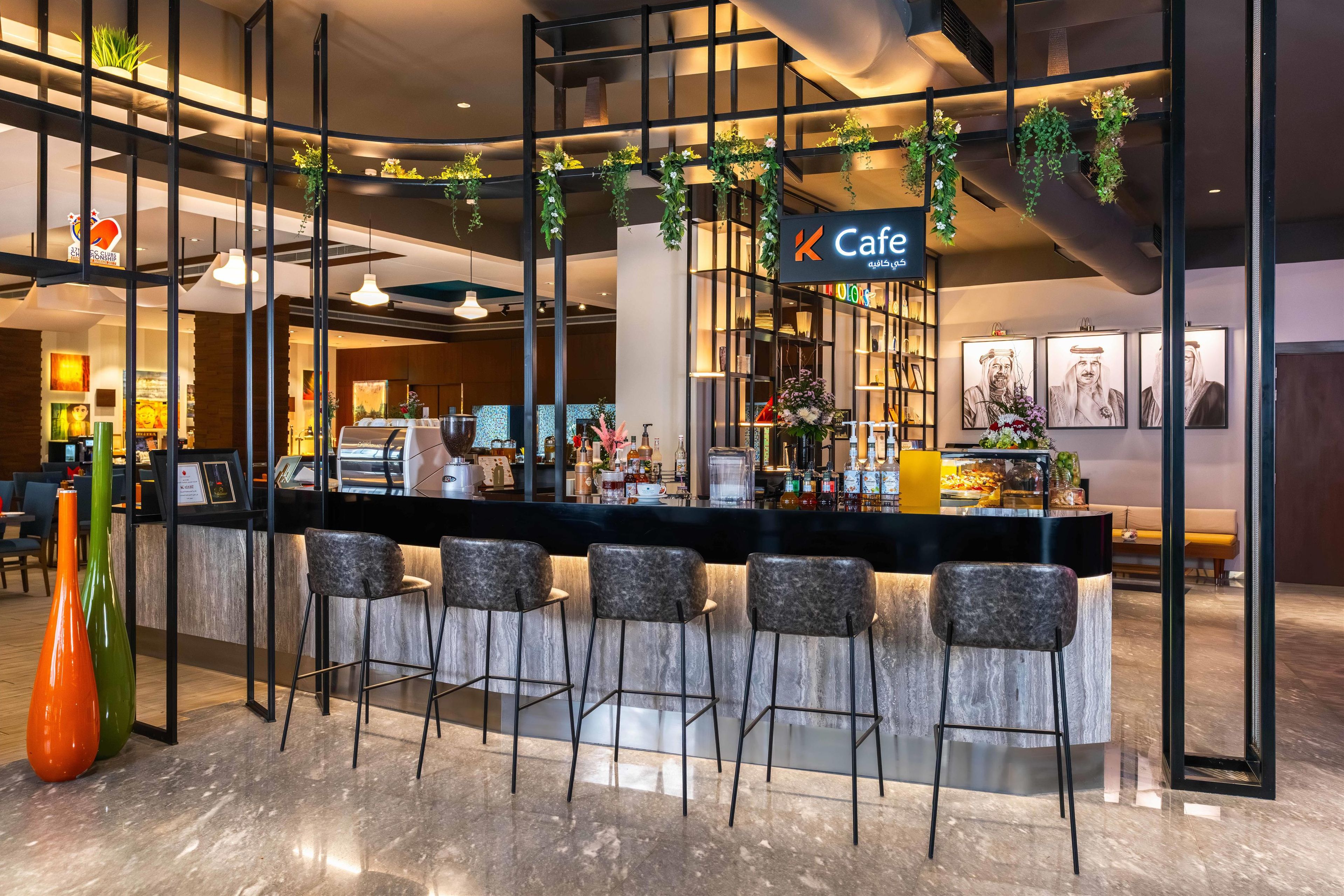 A modern cafe with a bar area, seating, and a counter with a menu display.