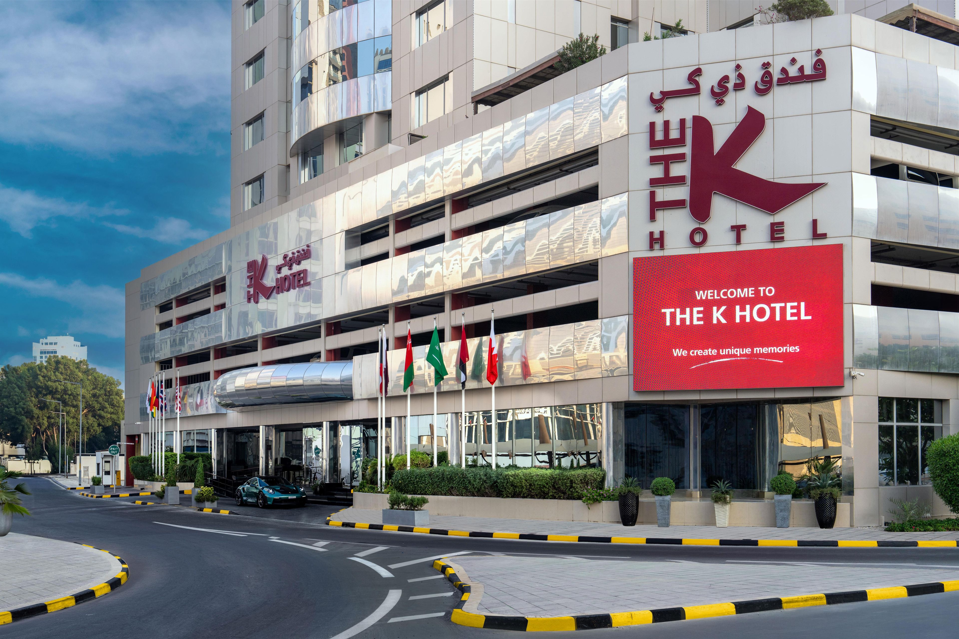 Een meerlaags hotel met een opvallend rood bord waarop 