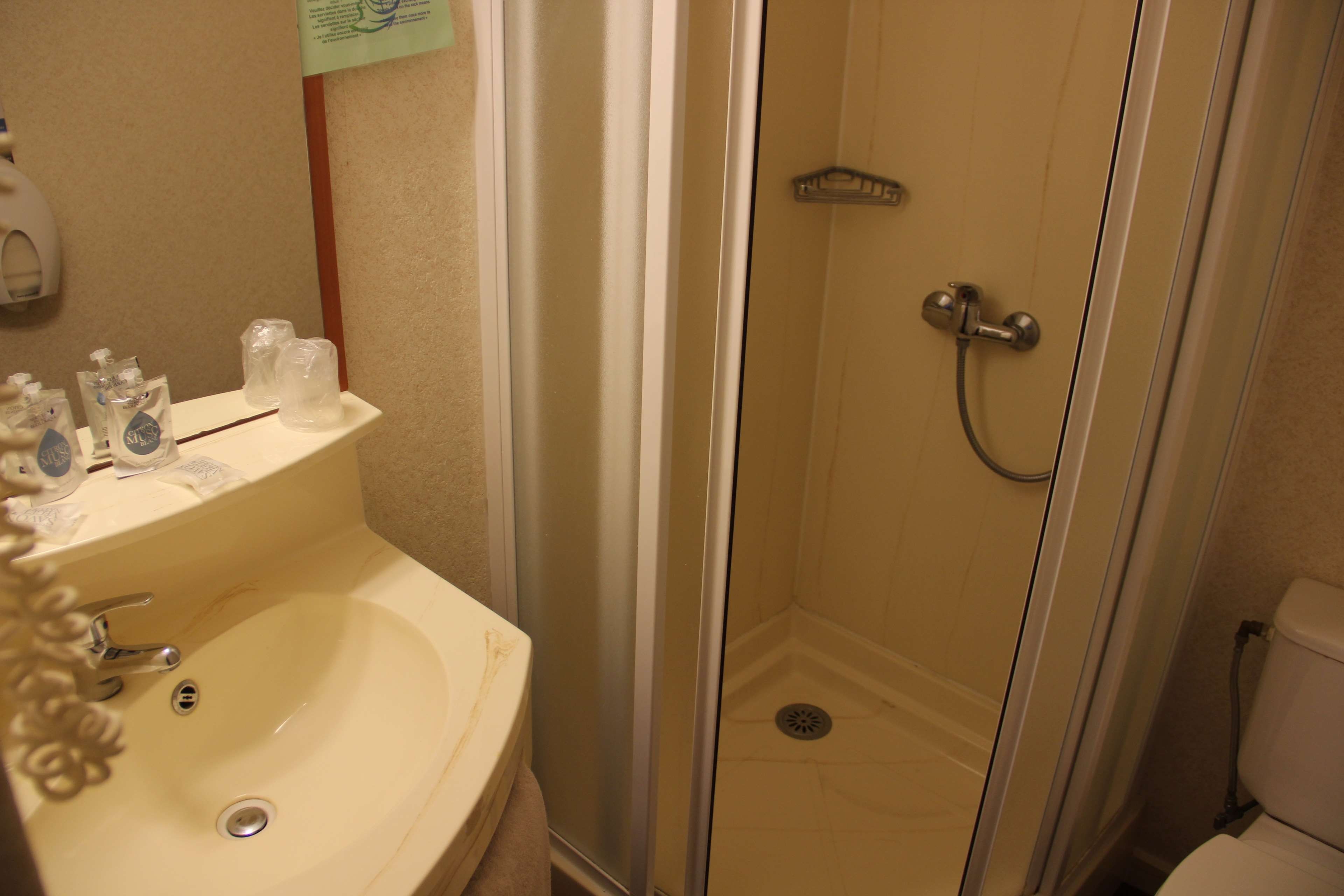 A bathroom with a sink, a shower, and a toilet.