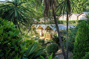 Ein tropisches Resort mit mehreren Bungalows, umgeben von üppiger Vegetation und Palmen.