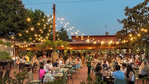 An outdoor dining area with string lights, tables, and chairs.